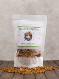 Packaged granola labeled 'GUSTERNOLA MILLER MIX GRANOLA' displayed on a wooden surface.