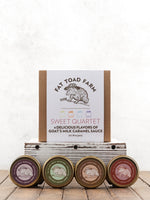 Fat Toad Farm sweet quartet with four jars of goat's milk caramel sauce on a wooden surface.