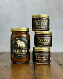 Three jars of Fat Toad Farm Caramel Claire's Maple Reserve on a wooden surface with a gray background.
